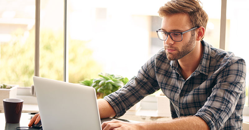 man on laptop studying for St John's University